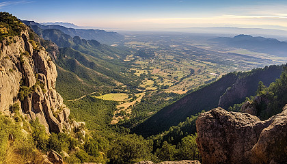 A panoramic view from a mountaintop, overlooking vast valleys and ranges.