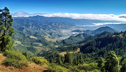 A panoramic view from a mountaintop, overlooking vast valleys and ranges.