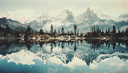 The mirror-like reflection of mountains on a glassy lake.